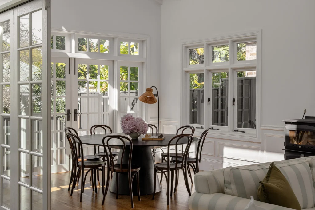 Bright dining area with french doors, bentwood chairs and copper pendant light